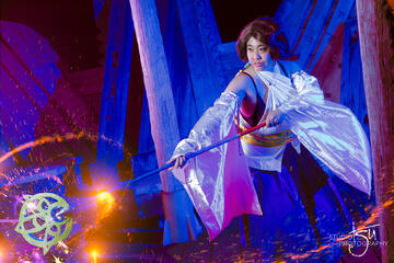 Pōhutukaryl Cosplay as Yuna from Final Fantasy X, sweeping a staff with sparks coming from it