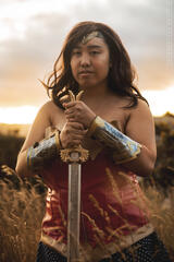 Pōhutukaryl Cosplay as Wonder Woman, steely eyed, holding a sword blade down